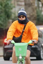 Harry Styles Stands Out in an Orange Puffer on Birthday Bike Ride in London