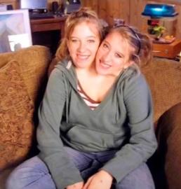 Conjoined Twins Abby and Brittany Carry a Baby Car Seat to Visit Workplace